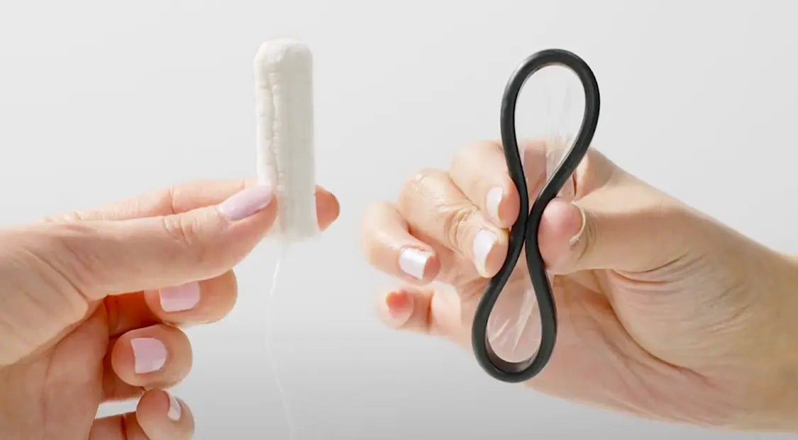 Hands holding a tampon and a flexible menstrual disc for comparison