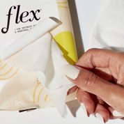 Hand pulling an intimate wipe from a menstrual care wipe package