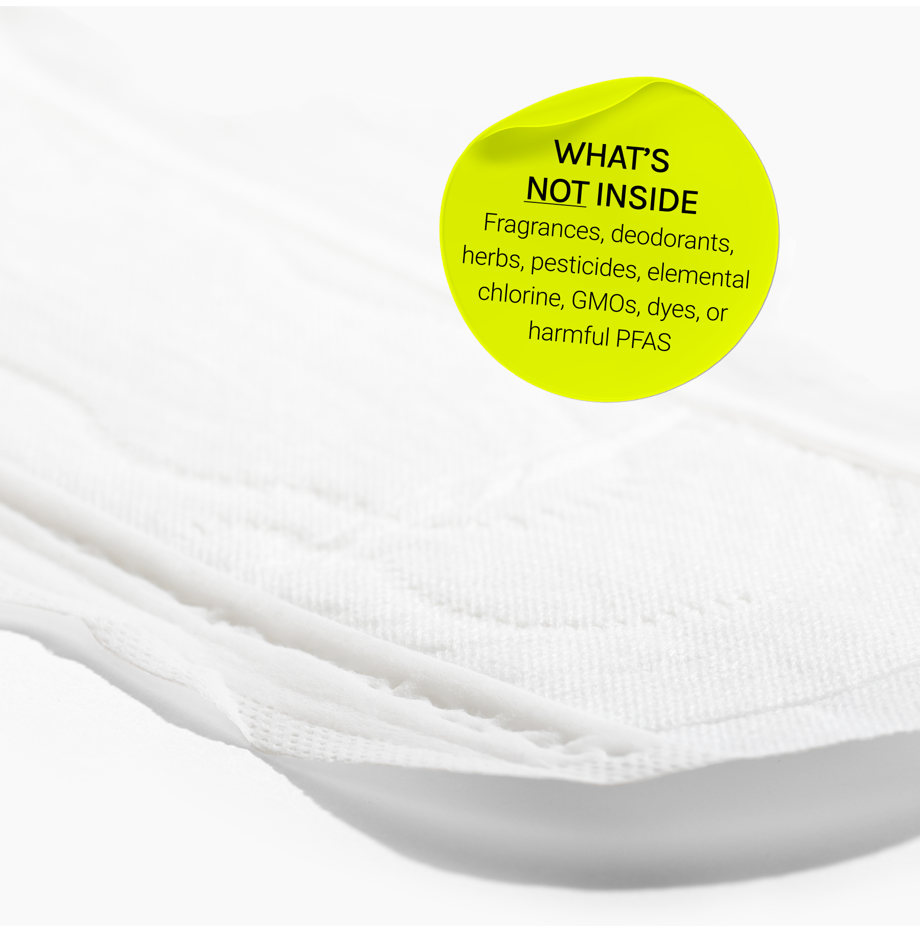 Close-up of menstrual pad with overlay text listing excluded ingredients and material information.