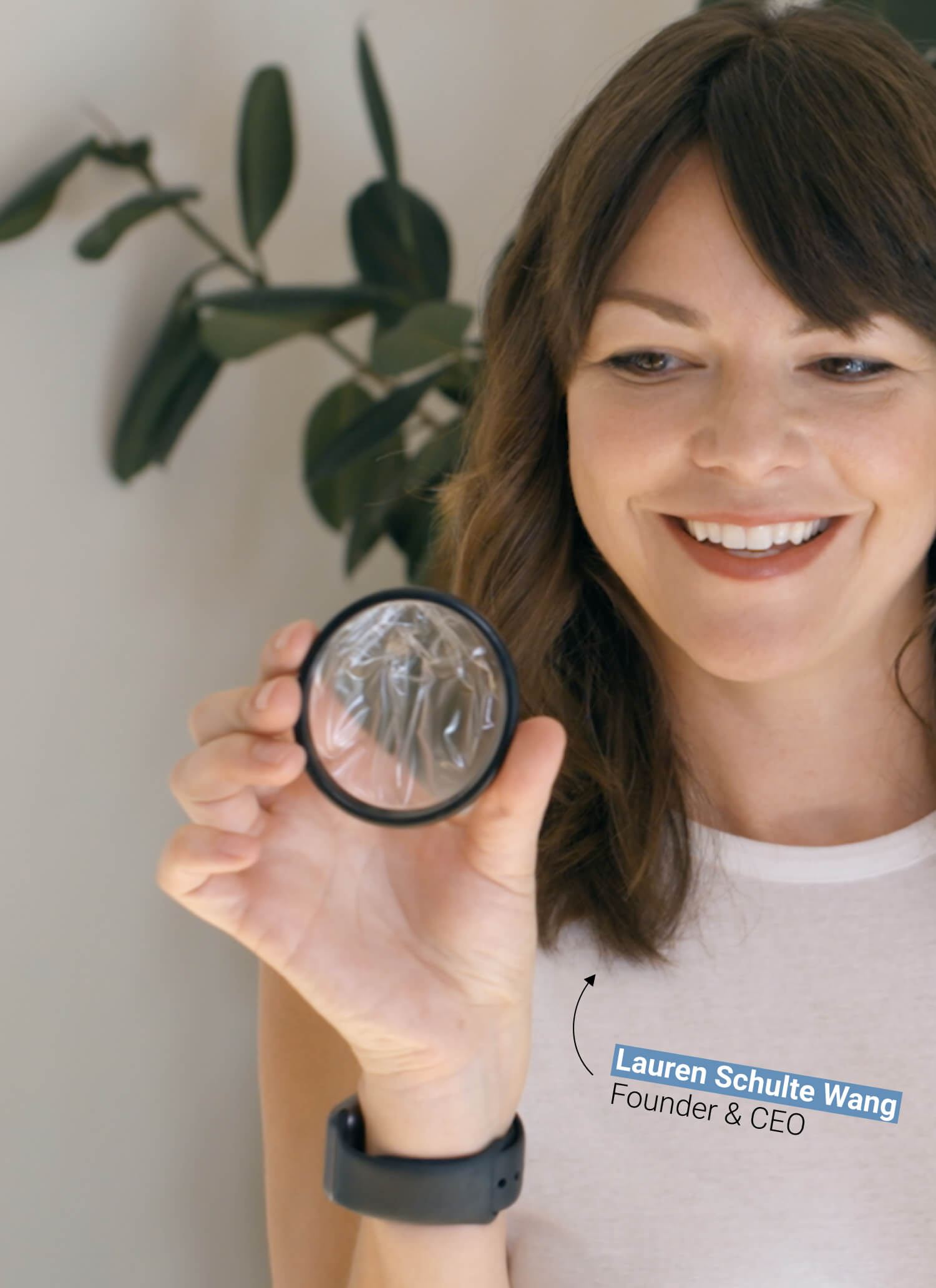 Smiling woman holding a menstrual disc near her face