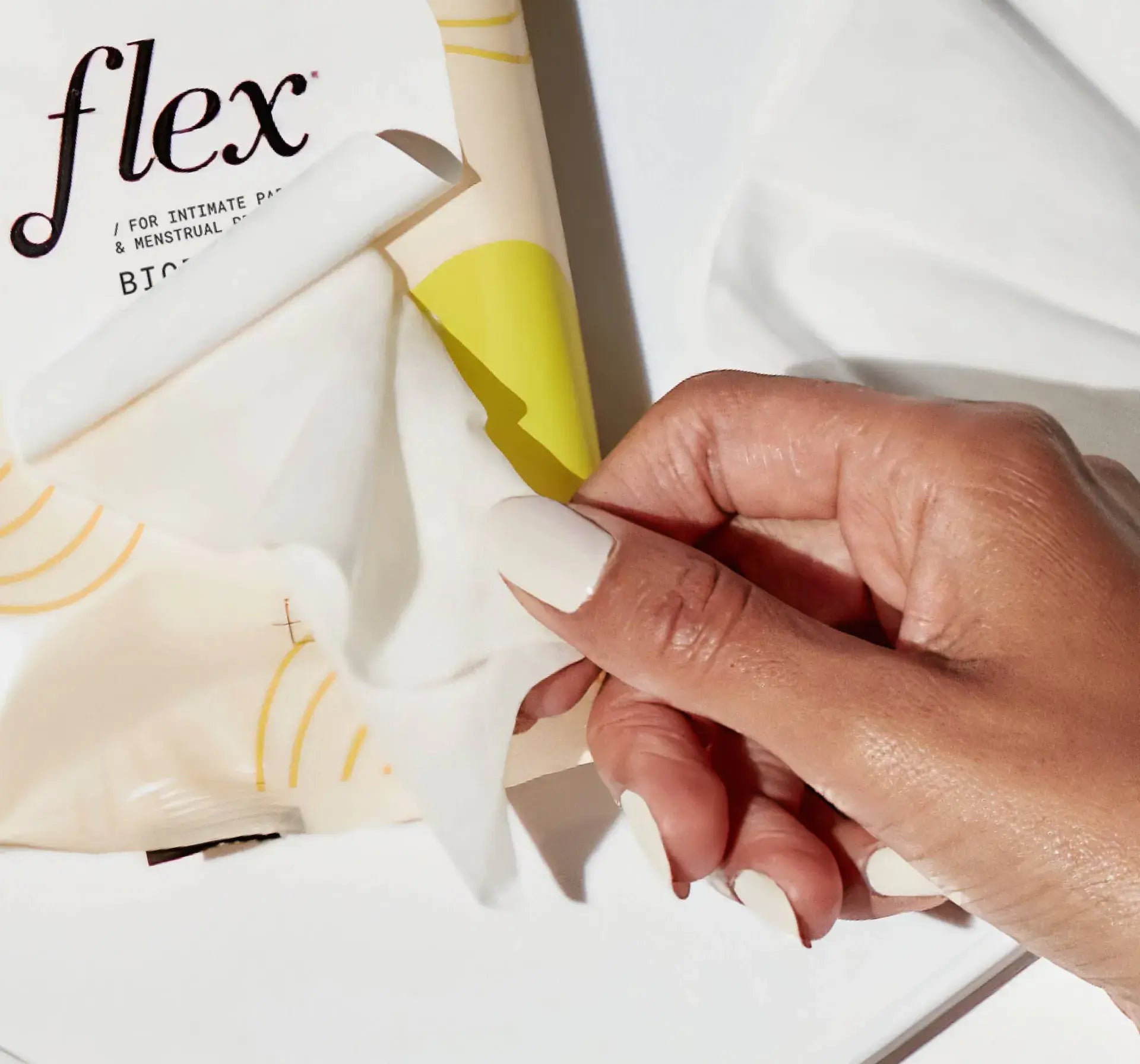 A person pulling out flex plant plus wipes out of a pack of wipes