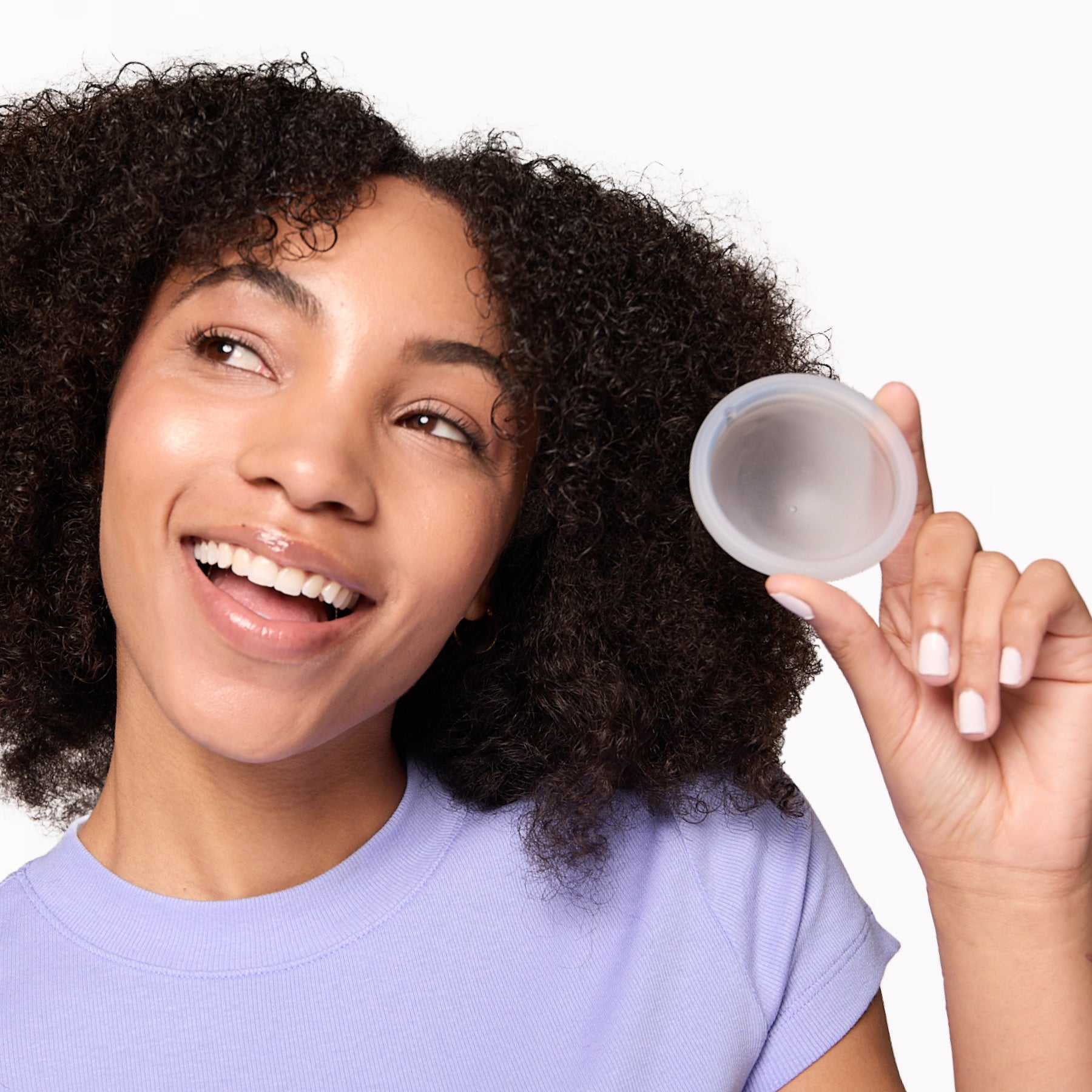 A person happy and smiling holding a Flex Reusable Menstrual Disc