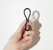 Hand holding a flexible menstrual disc pinched into figure-eight shape