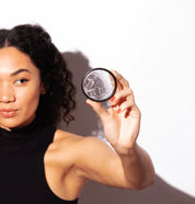 Person holding a round container with individually wrapped menstrual discs