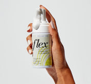 A person's hand holding a bottle of flex ph balanced foaming cleanser